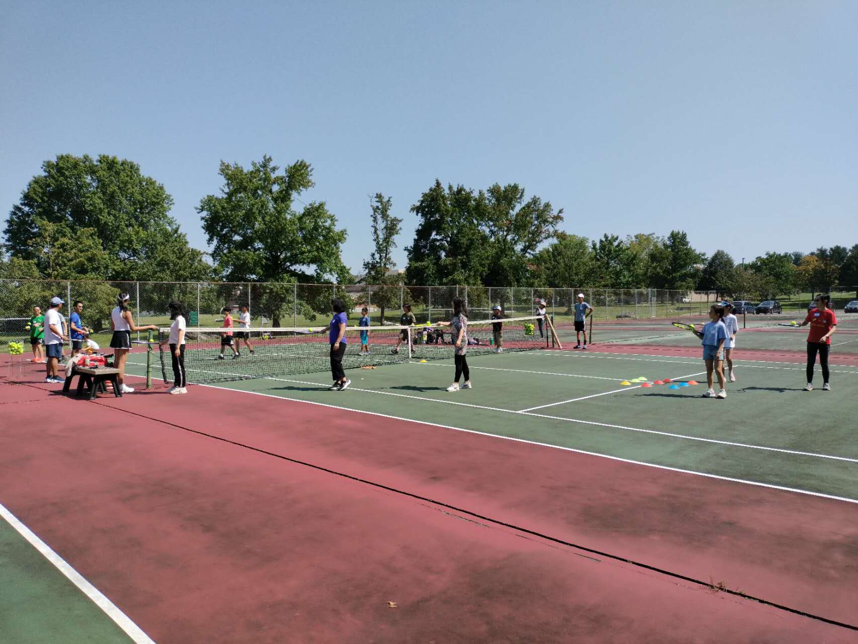 Children and parents practicing tennis together at HXCS-LV
