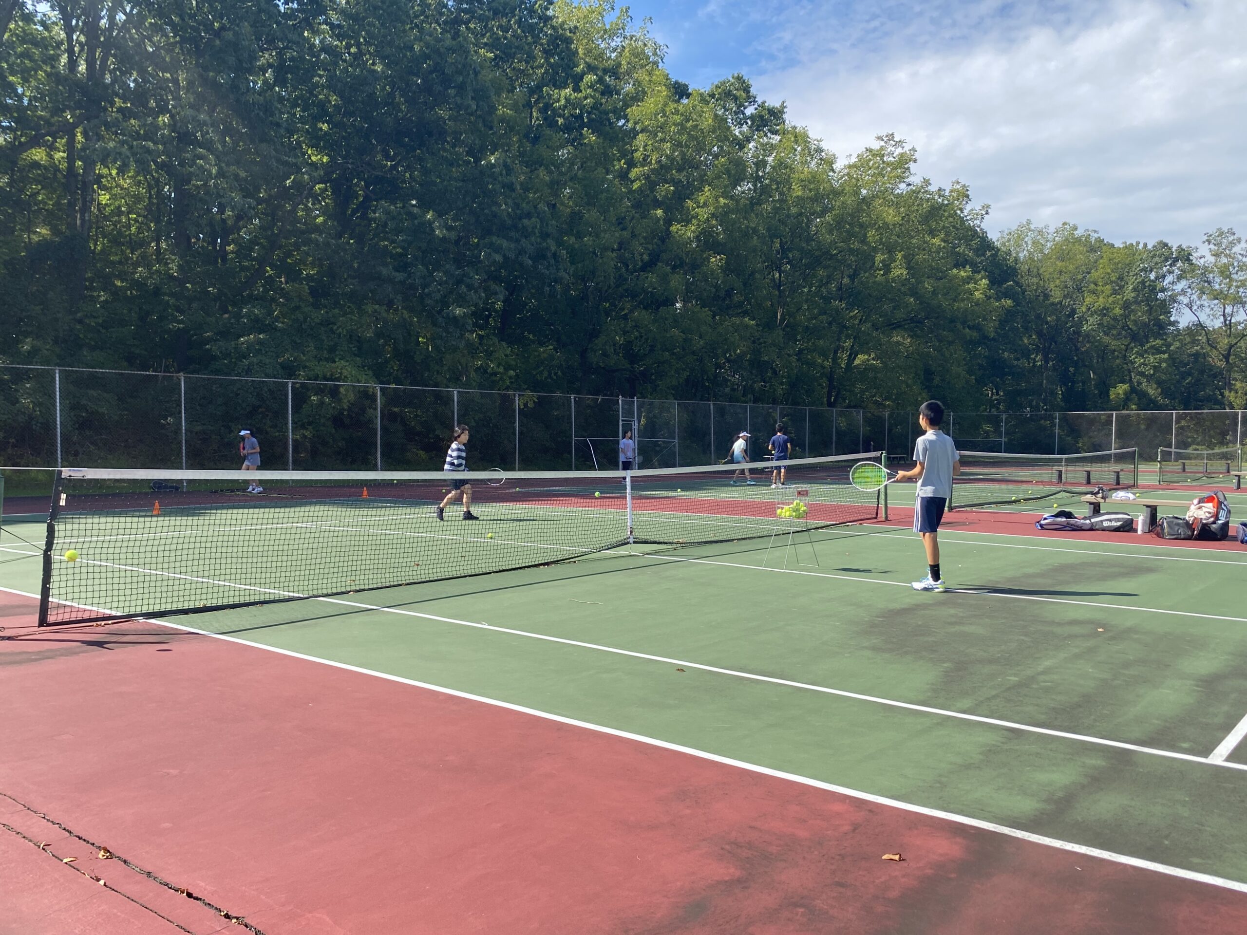 Coach Kevin Yao working with players during the 2023 fall tennis club