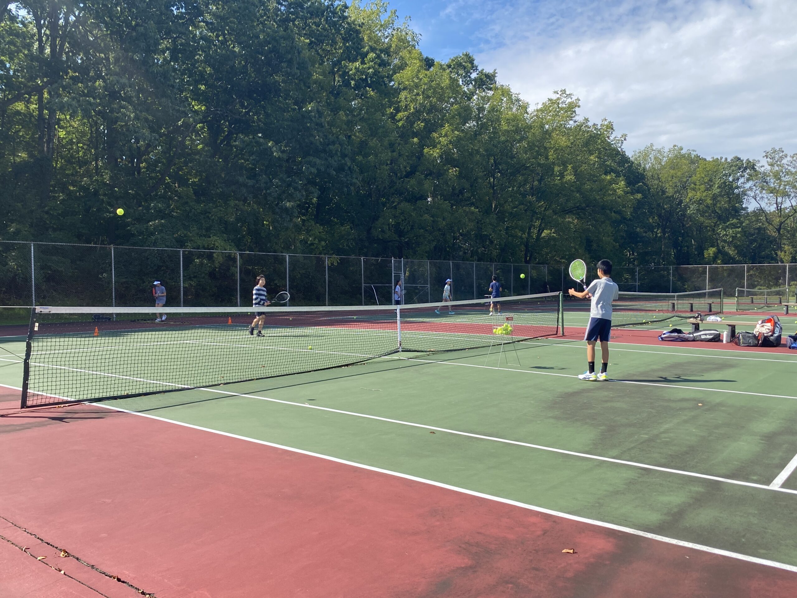 Students practicing tennis fundamentals during the fall club