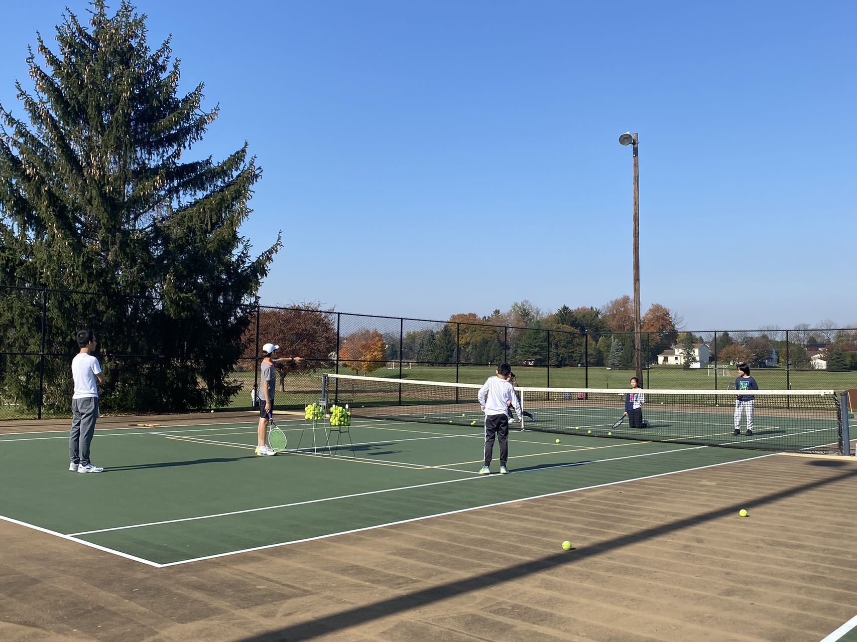 Students and coaches at a 2023 fall tennis club practice