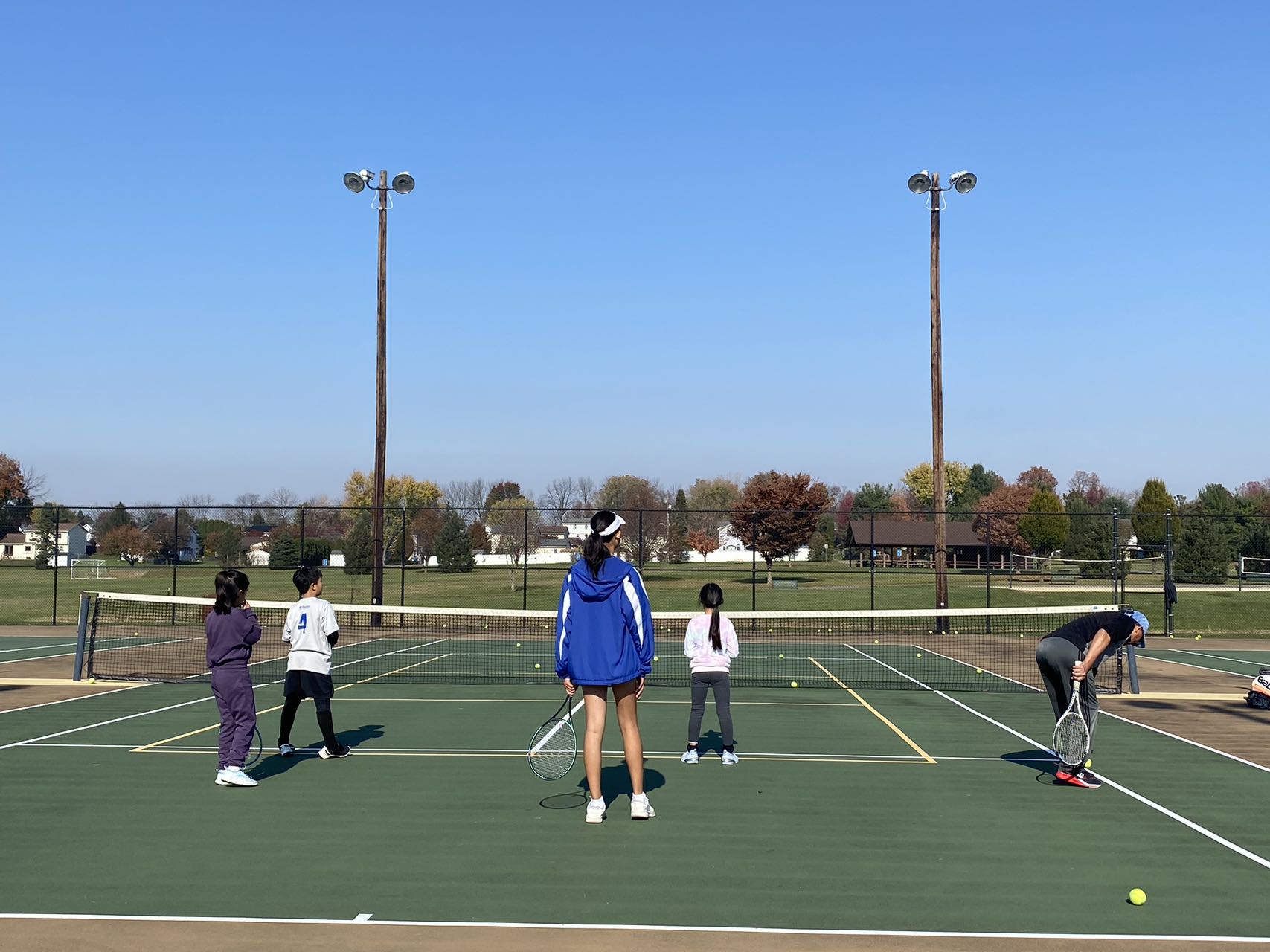 Fall tennis club players practicing together on the court