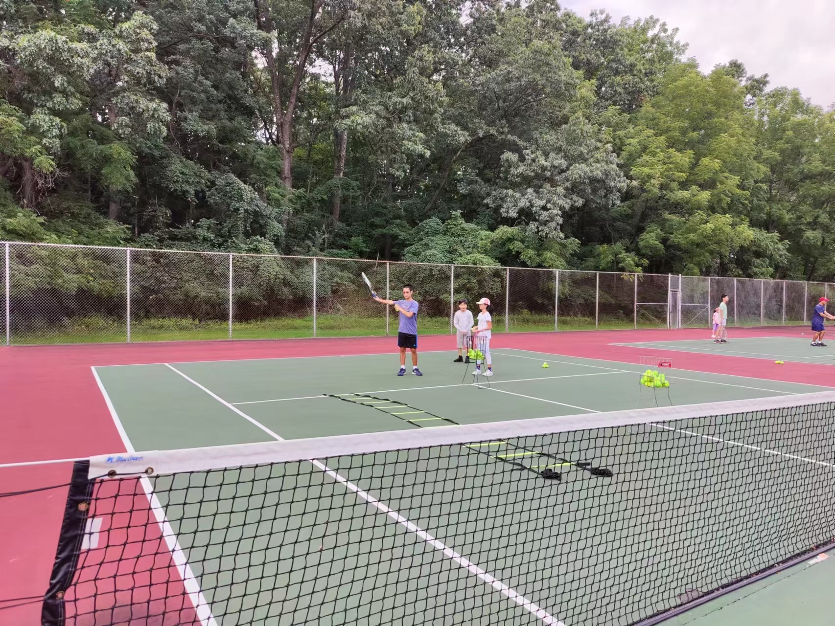 Fall tennis club players practicing with coaches