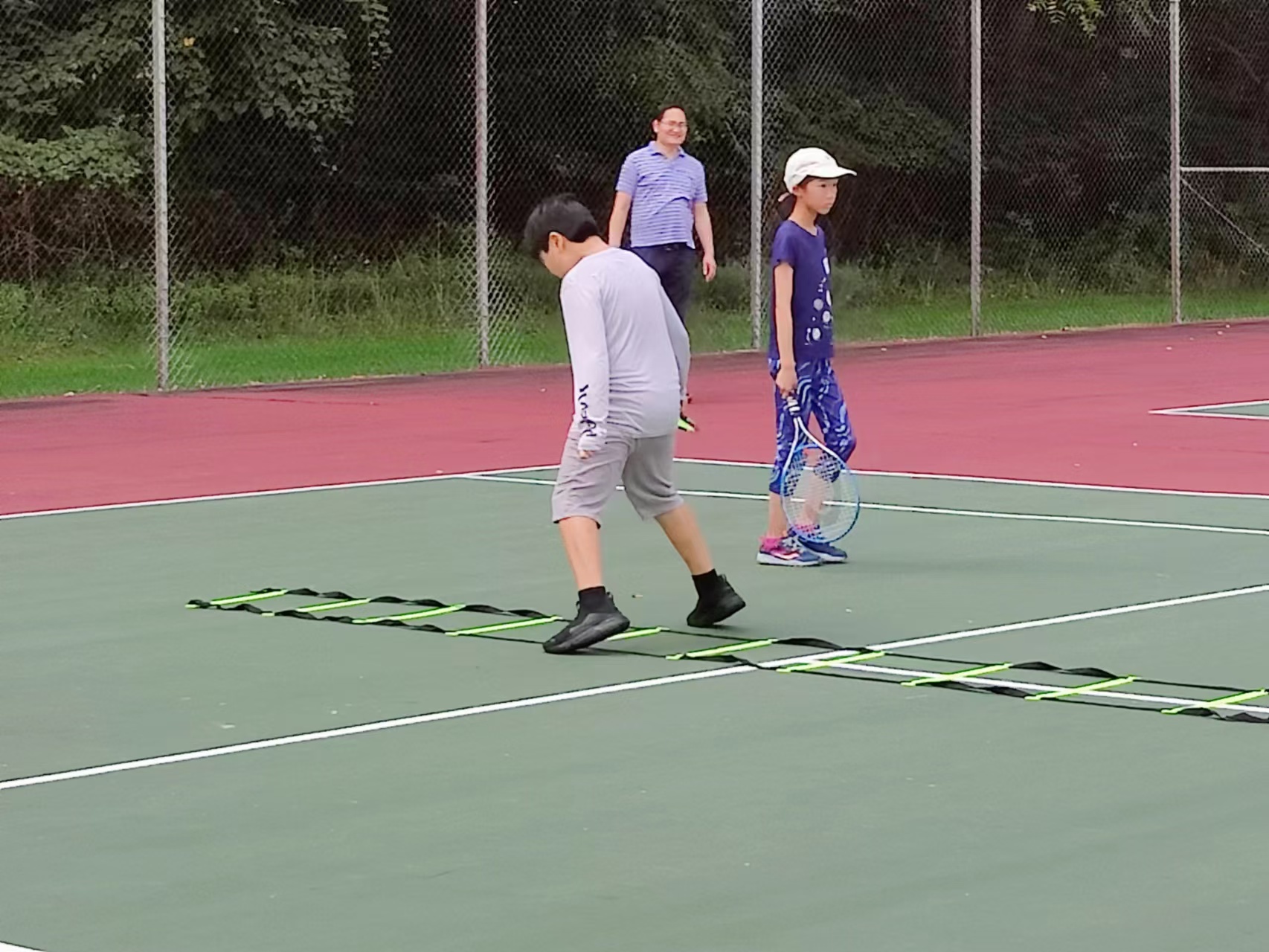 Young players completing an agility-ladder drill during the 2022 fall tennis club