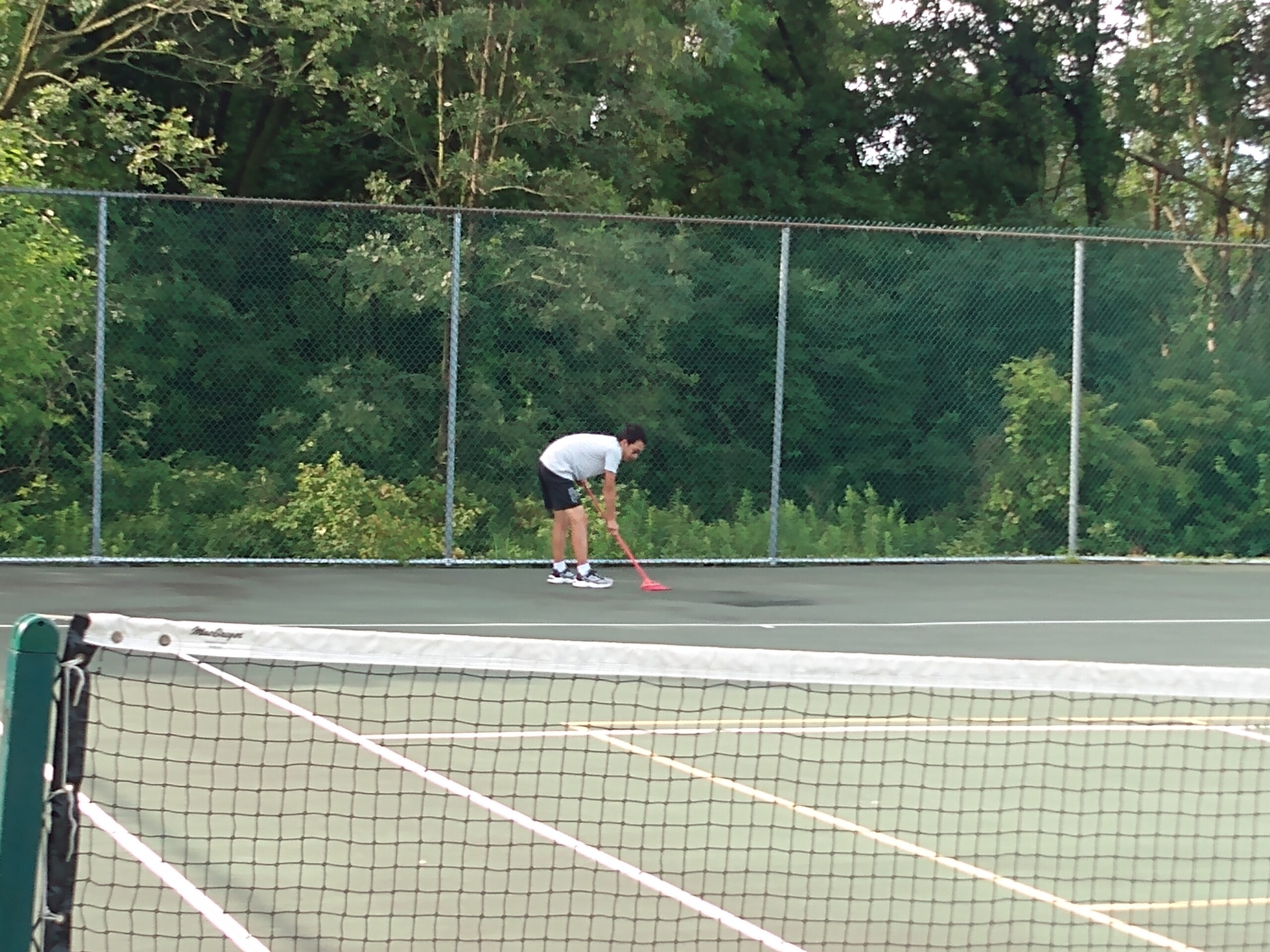 The summer camp coaches cleaning the court before practice