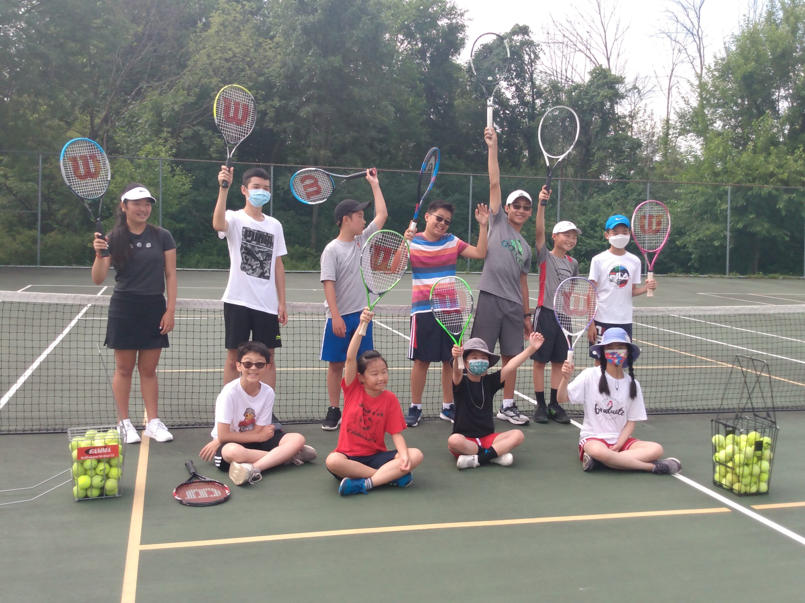 The 2021 summer camp group gathered on the tennis court